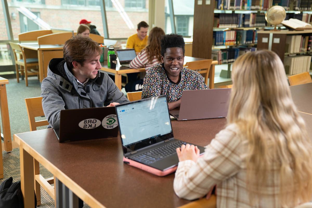 students with laptops at a table